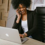 Une femme passe un coup de fil devant son ordinateur