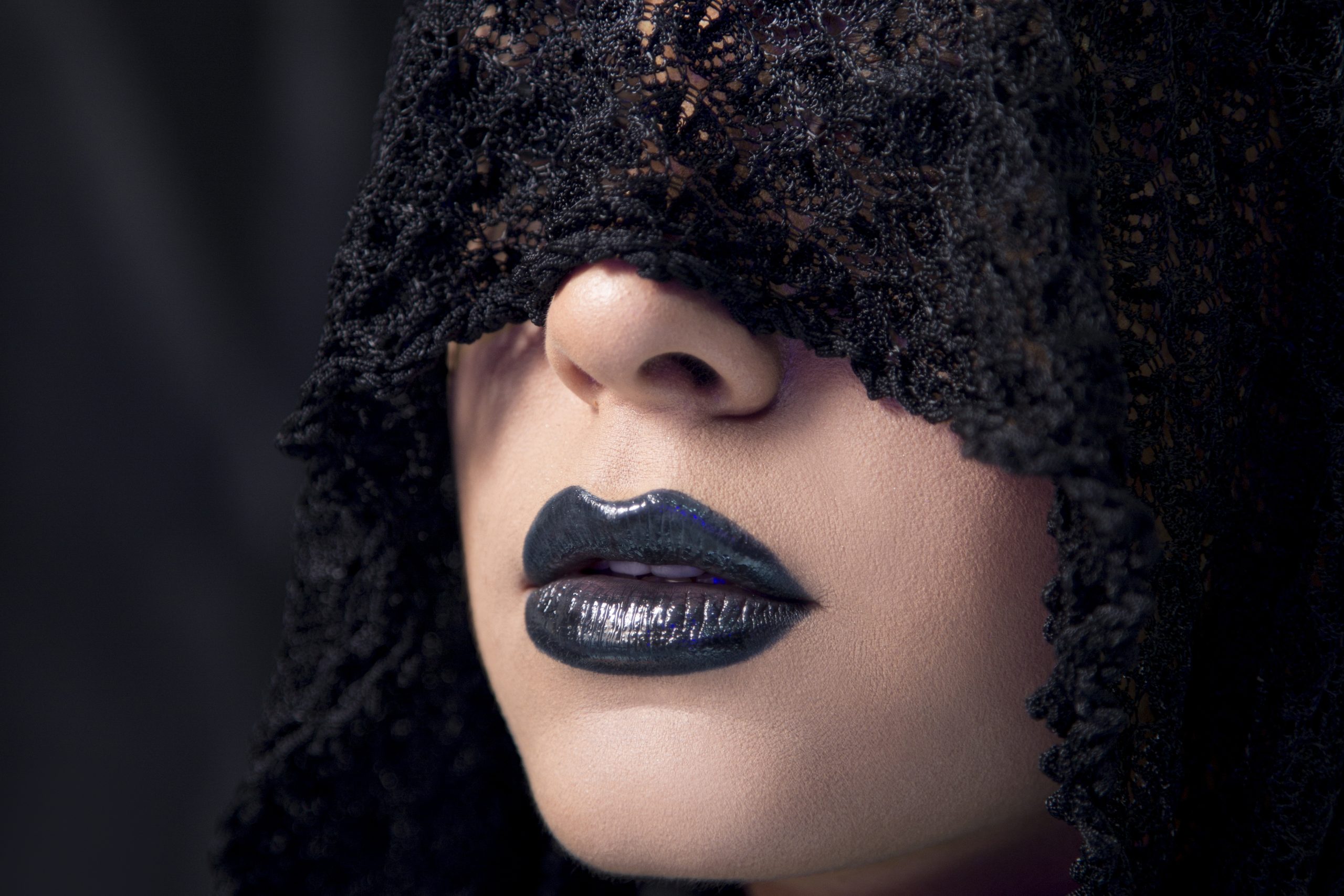 Modèle féminin portant un maquillage de style gothique avec un foulard en dentelle noire