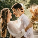 man in white dress shirt holding brown flower bouquet