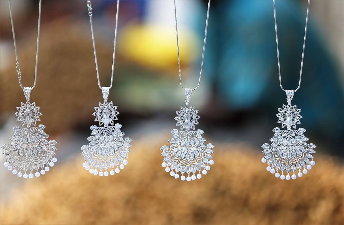 Quatre pendentifs en argent ornés de perles suspendus sur fil Quatre pendentifs en argent ornés de perles suspendus sur fil